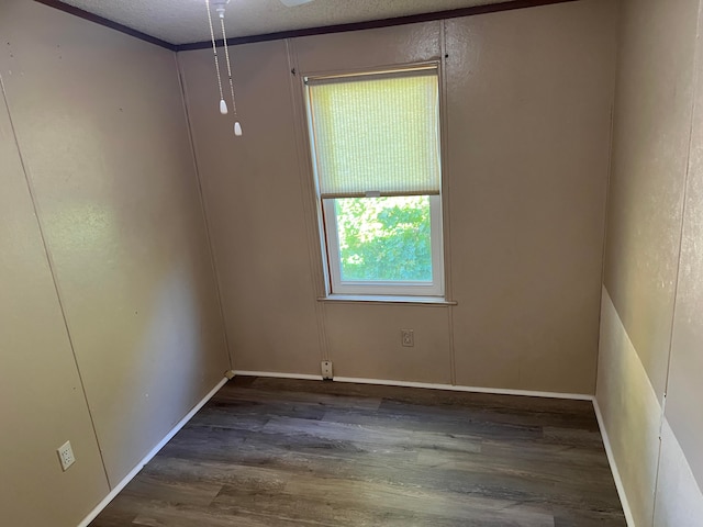 spare room with dark wood-type flooring and a textured ceiling