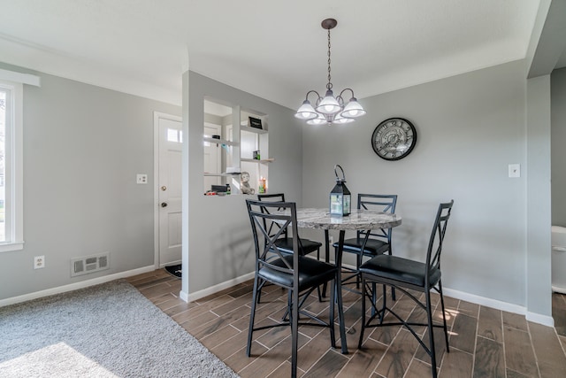 dining room featuring a chandelier, plenty of natural light, and dark wood-type flooring