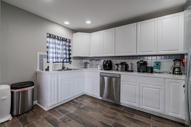 kitchen featuring white cabinetry, sink, dark wood-type flooring, stainless steel dishwasher, and decorative backsplash