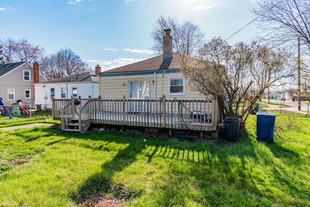 rear view of property with a lawn and a deck