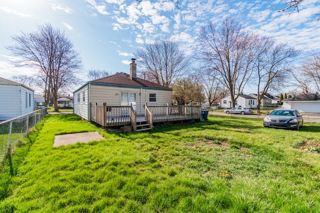 back of house featuring a lawn and a deck