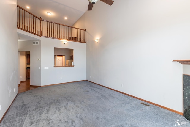 unfurnished living room featuring ceiling fan, carpet flooring, and high vaulted ceiling