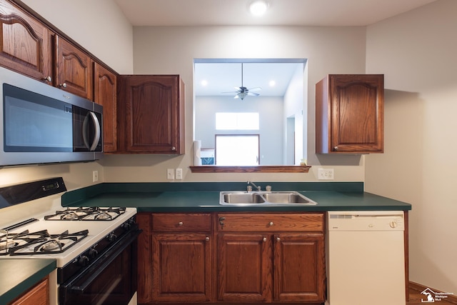 kitchen with white dishwasher, sink, gas range oven, and ceiling fan