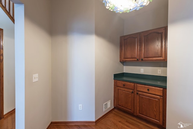 kitchen featuring wood-type flooring and a notable chandelier