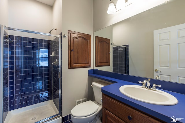 bathroom featuring toilet, tiled shower, and vanity