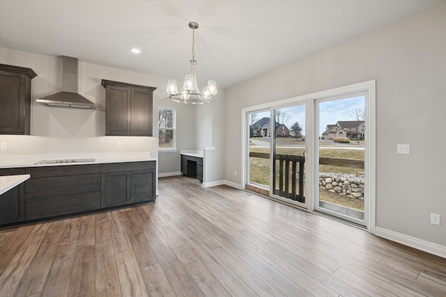 unfurnished dining area featuring light wood finished floors, recessed lighting, baseboards, and an inviting chandelier