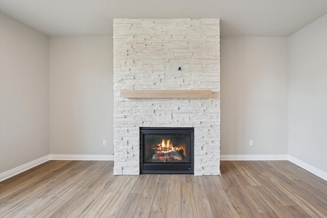 room details with a fireplace, wood finished floors, and baseboards