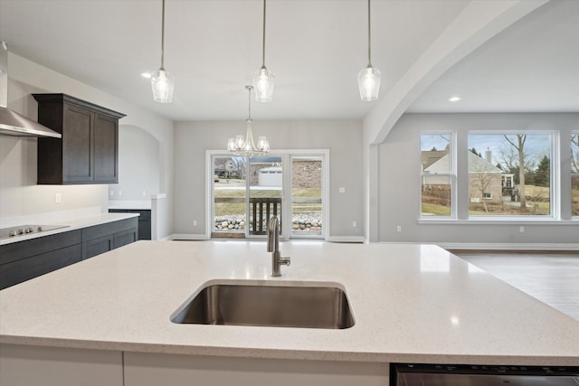 kitchen featuring a sink, arched walkways, wall chimney exhaust hood, black electric stovetop, and dishwasher