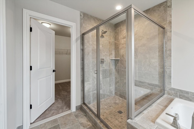 full bath with a spacious closet, baseboards, recessed lighting, a stall shower, and a bath