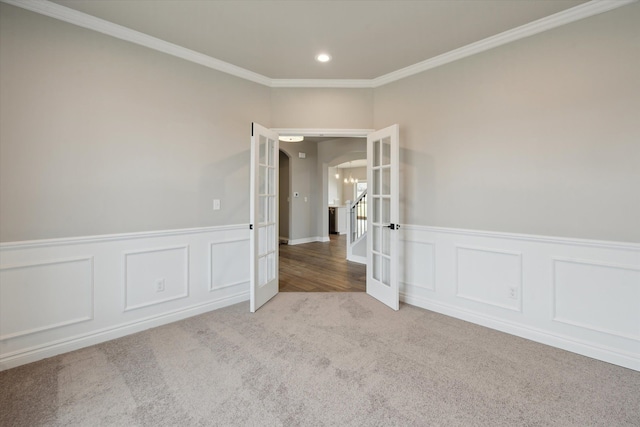 unfurnished room featuring carpet floors, recessed lighting, arched walkways, ornamental molding, and french doors