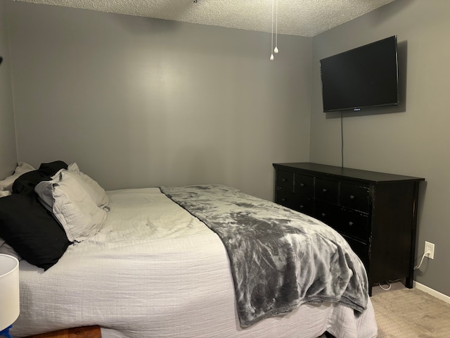 bedroom featuring light colored carpet and a textured ceiling