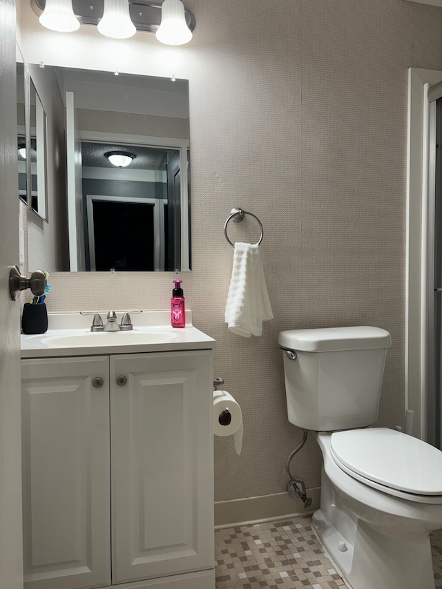 bathroom with tile patterned flooring, vanity, and toilet