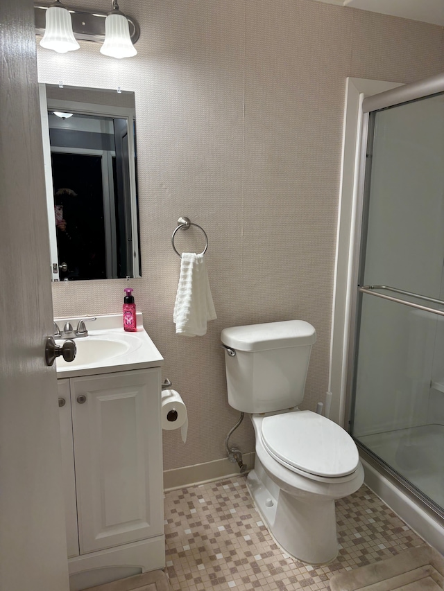 bathroom with tile patterned flooring, a shower with door, vanity, and toilet