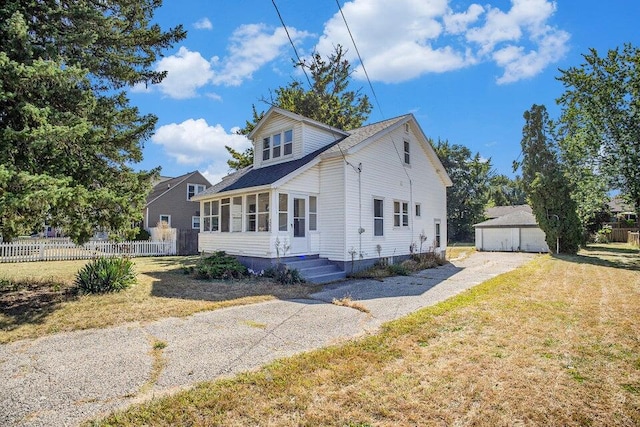 view of front of property with a front yard, a garage, and an outdoor structure