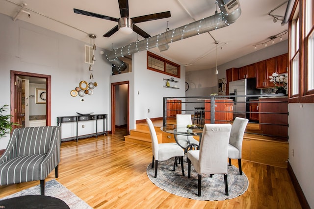 dining space featuring ceiling fan, rail lighting, and light hardwood / wood-style floors