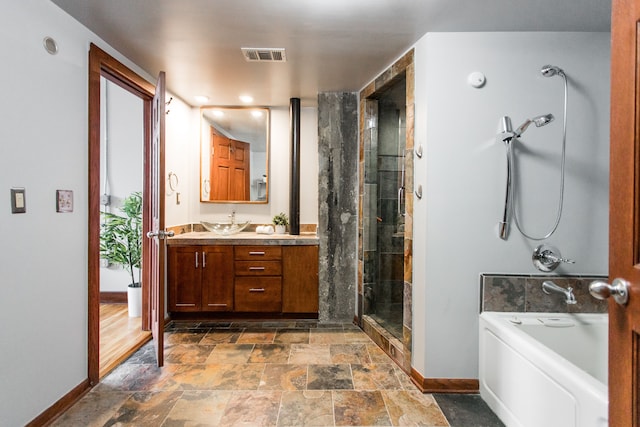 bathroom featuring vanity and independent shower and bath