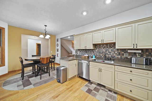 kitchen featuring sink, dishwasher, hanging light fixtures, light hardwood / wood-style floors, and cream cabinetry