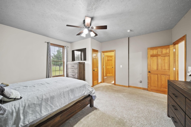 bedroom featuring ceiling fan, a textured ceiling, and light carpet