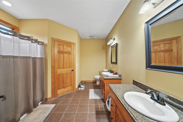 bathroom with tile patterned flooring, vanity, and toilet