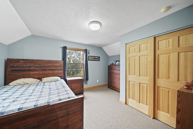 bedroom with carpet flooring, a textured ceiling, vaulted ceiling, and a closet