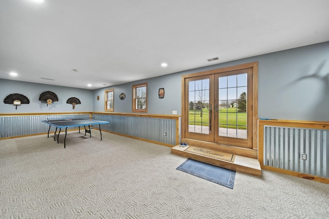 game room with wooden walls and light colored carpet