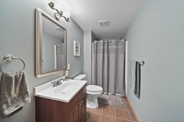 bathroom featuring vanity, tile patterned floors, toilet, a textured ceiling, and walk in shower