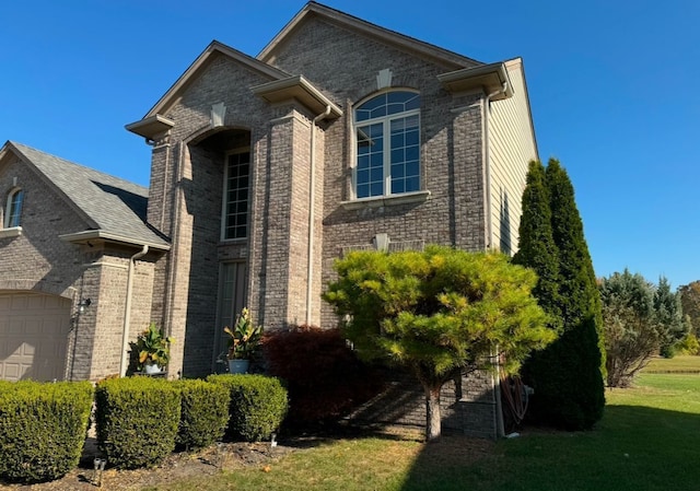 22031 Goldenwillow Dr, Macomb, MI 48044 - view of front of house featuring an attached garage, a front yard, and brick siding