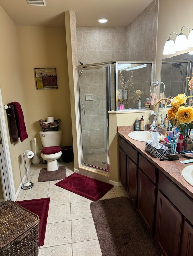 bathroom featuring tile patterned flooring, vanity, toilet, and walk in shower