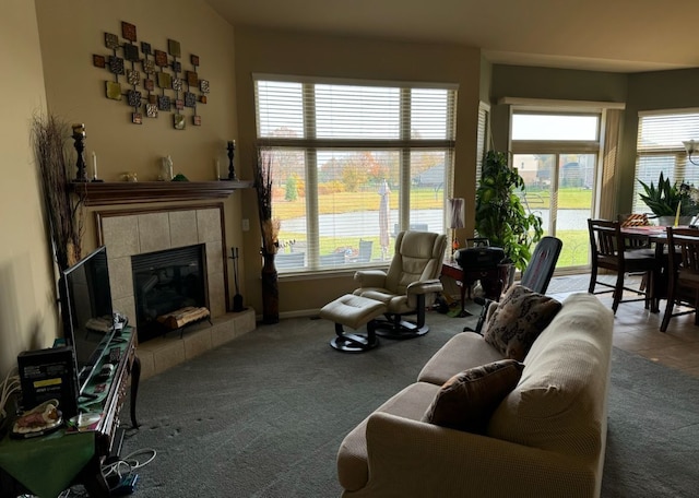 living room featuring a tiled fireplace and carpet flooring