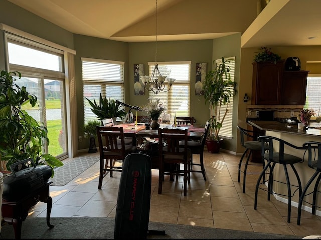 dining room with a notable chandelier, lofted ceiling, and light tile patterned floors