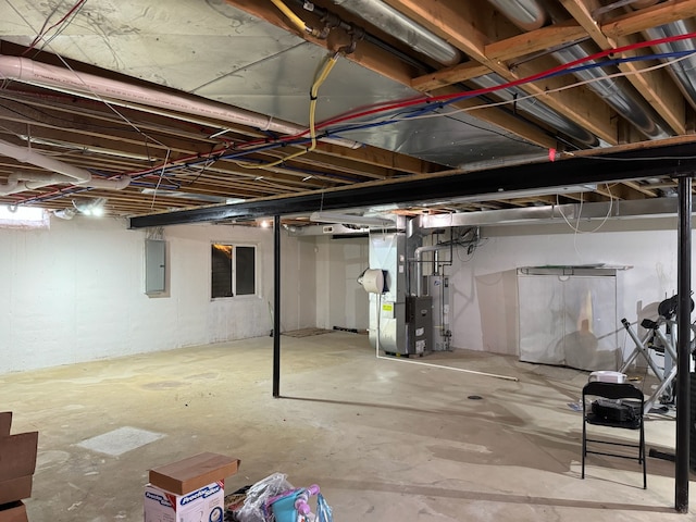 basement featuring heating unit, gas water heater, and electric panel