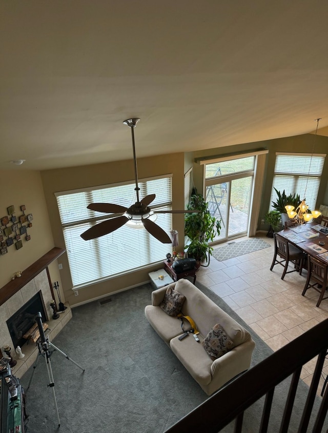 living room featuring light carpet, vaulted ceiling, and a tile fireplace