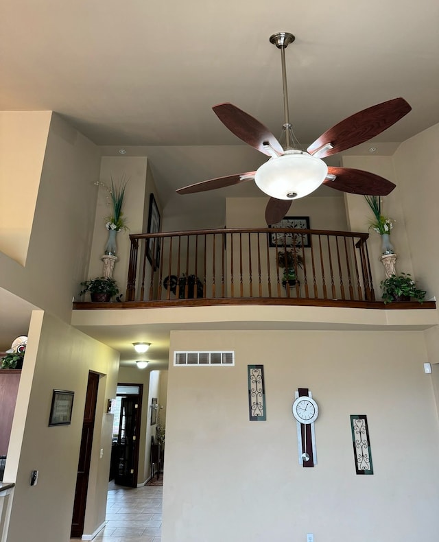 interior space with ceiling fan and a high ceiling