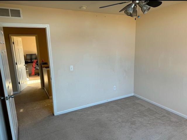 carpeted spare room featuring ceiling fan