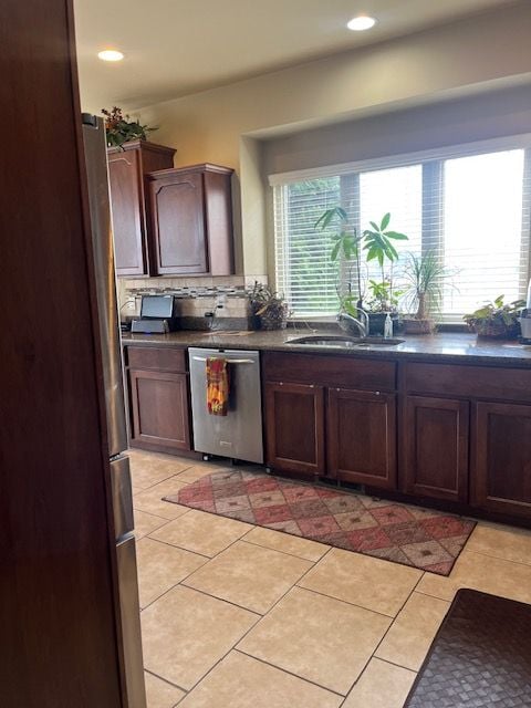 22031 Goldenwillow Dr, Macomb, MI 48044 - kitchen with a sink, dark countertops, light tile patterned floors, and stainless steel appliances