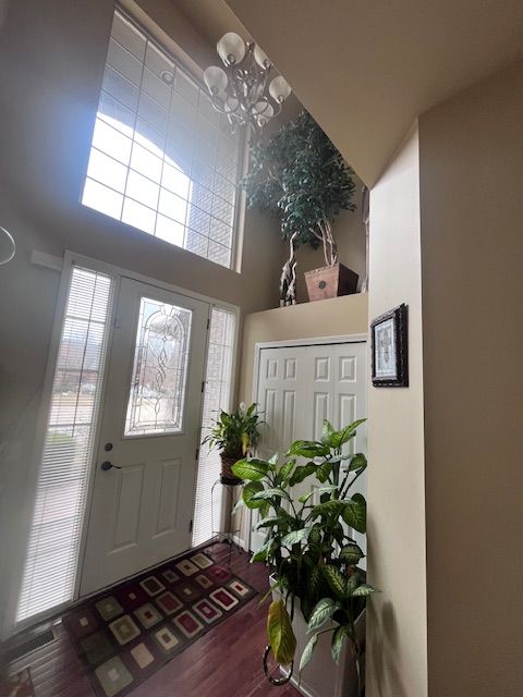 22031 Goldenwillow Dr, Macomb, MI 48044 - entryway with an inviting chandelier, wood finished floors, and a towering ceiling