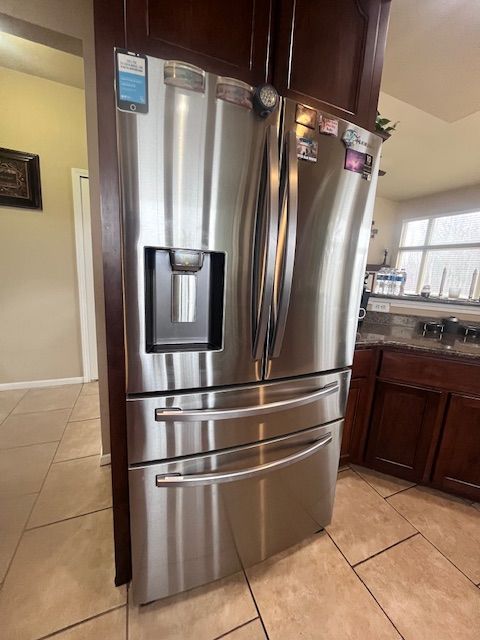 22031 Goldenwillow Dr, Macomb, MI 48044 - interior details featuring stainless steel fridge with ice dispenser, dark stone countertops, and dark brown cabinets