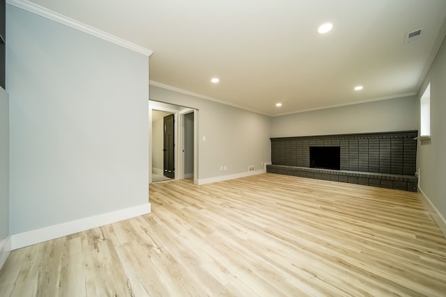 unfurnished living room featuring a fireplace, light hardwood / wood-style floors, and crown molding