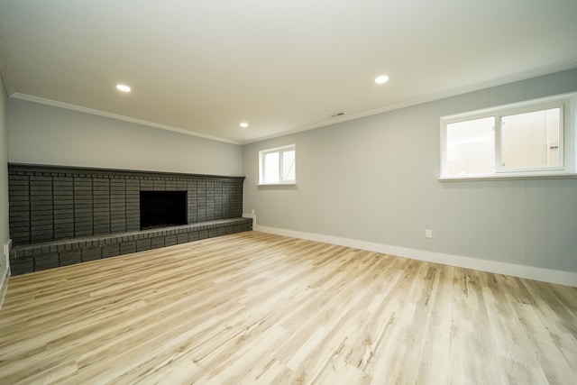 interior space with a fireplace, ornamental molding, and light wood-type flooring