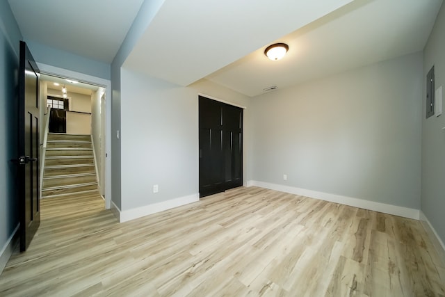 unfurnished bedroom featuring electric panel, a closet, and light wood-type flooring