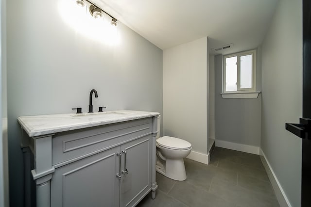 bathroom with tile patterned flooring, vanity, and toilet