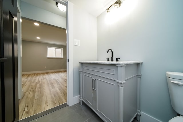 bathroom with vanity, hardwood / wood-style flooring, and toilet