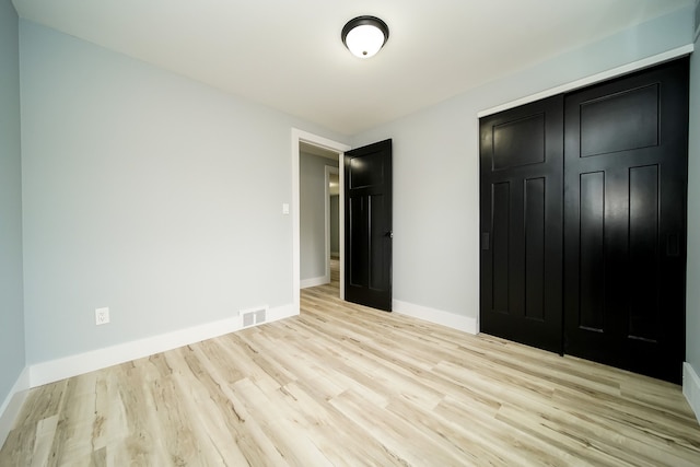 unfurnished bedroom featuring a closet and light hardwood / wood-style flooring