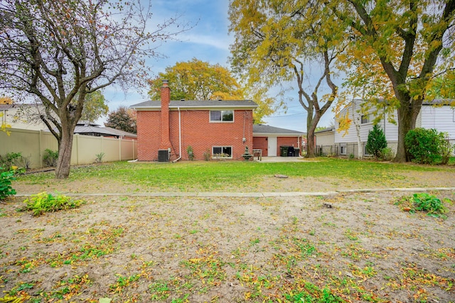 back of property featuring central air condition unit and a yard