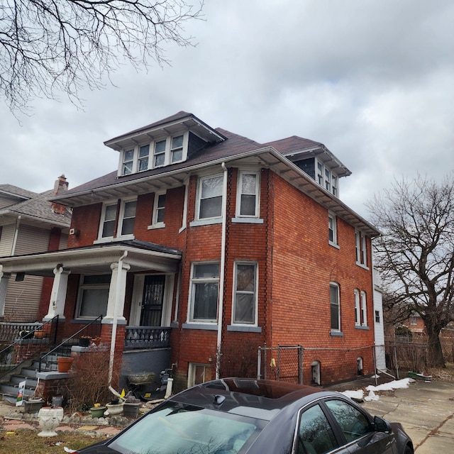 view of property exterior featuring brick siding and a porch