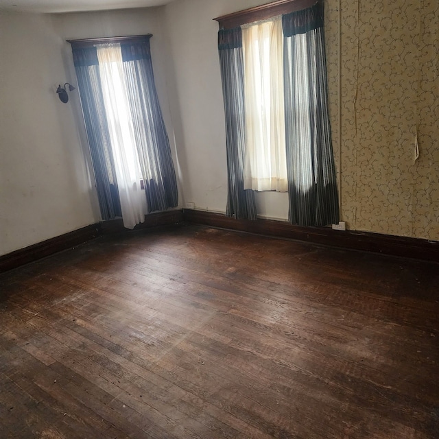 unfurnished room featuring dark wood finished floors and baseboards