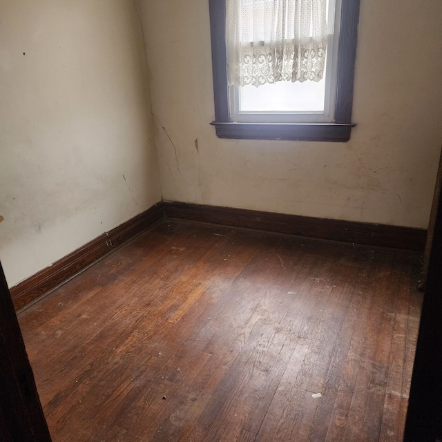 unfurnished room with baseboards and hardwood / wood-style floors