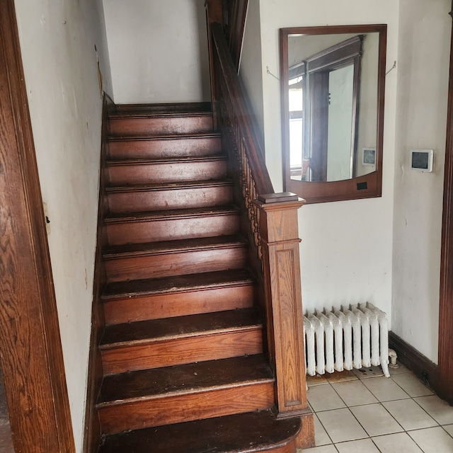 staircase with tile patterned floors and radiator