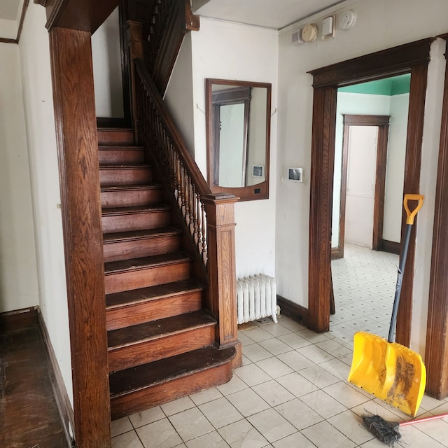 stairway featuring radiator heating unit and baseboards