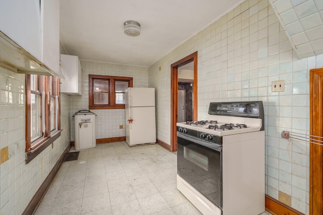 kitchen with white cabinets, white appliances, and tile walls